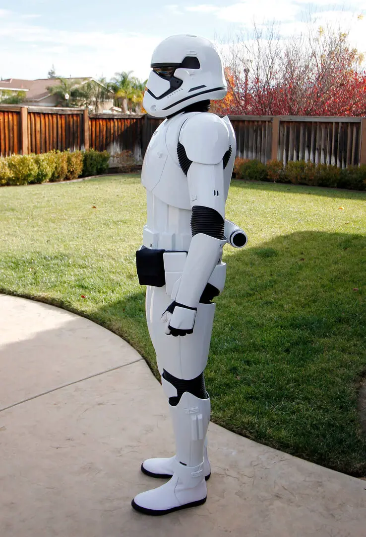 A person in a stormtrooper costume standing on the grass.