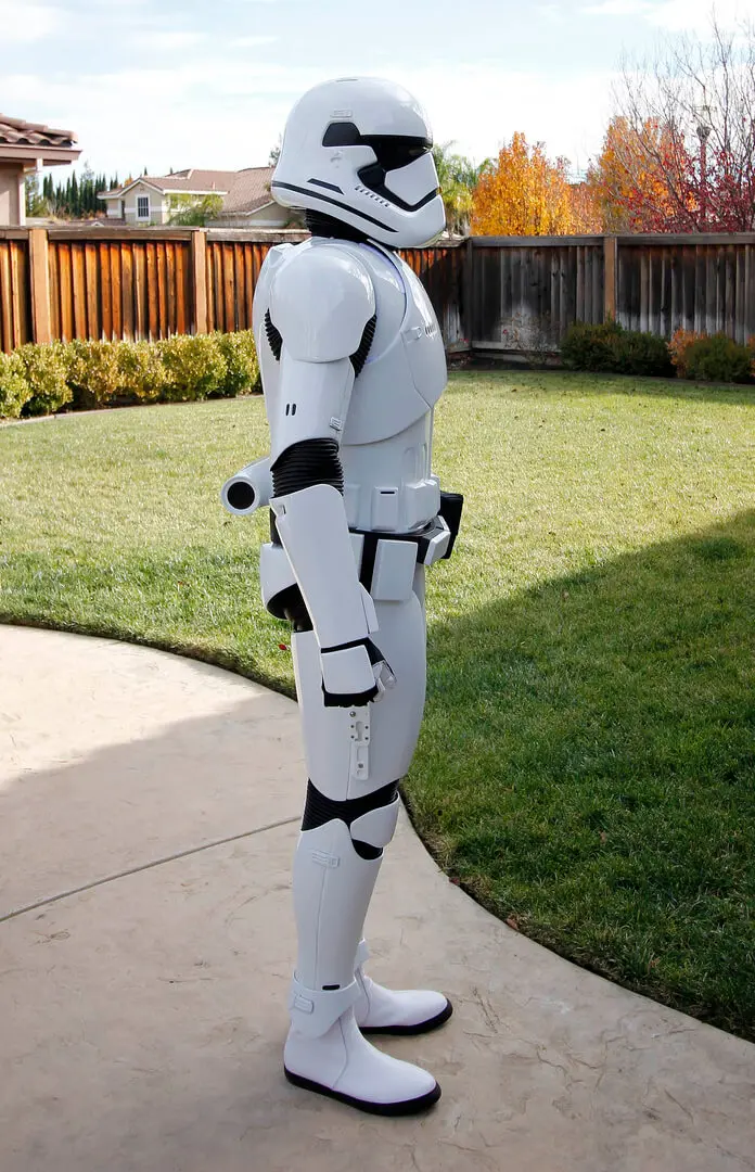 A person in a stormtrooper costume standing on the sidewalk.