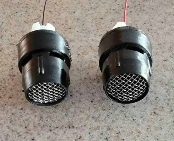 Two speakers are connected to wires and have a wire on them.