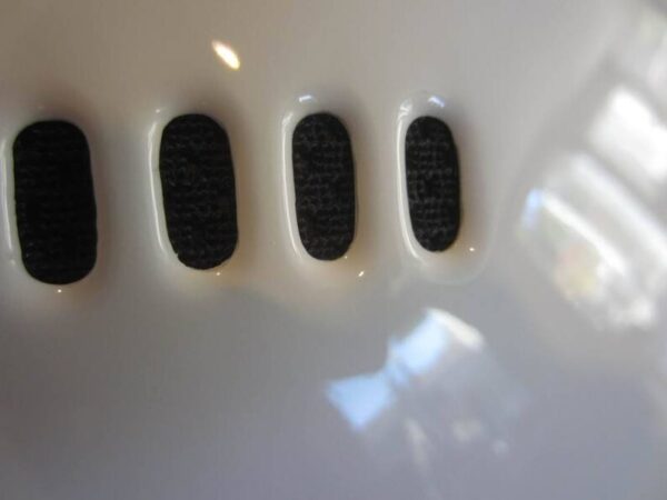 A close up of the four black buttons on a white surface.