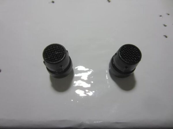 A pair of black knobs on the side of a white table.