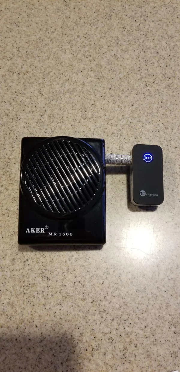 A black speaker sitting on top of a table.