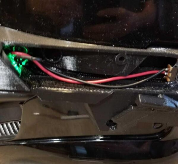 A car 's dashboard showing the wires and battery.