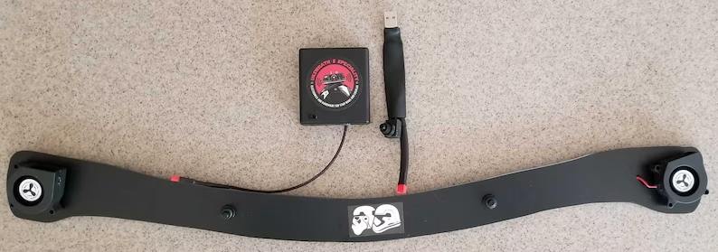 A black and red controller sitting next to a black belt.