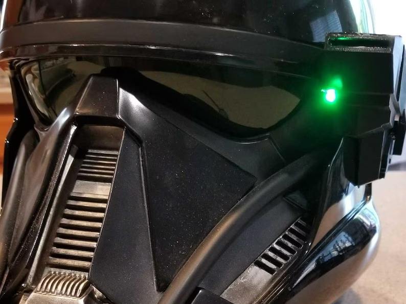 A close up of the helmet and green light