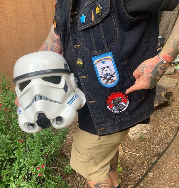 A person holding a star wars helmet and some other items