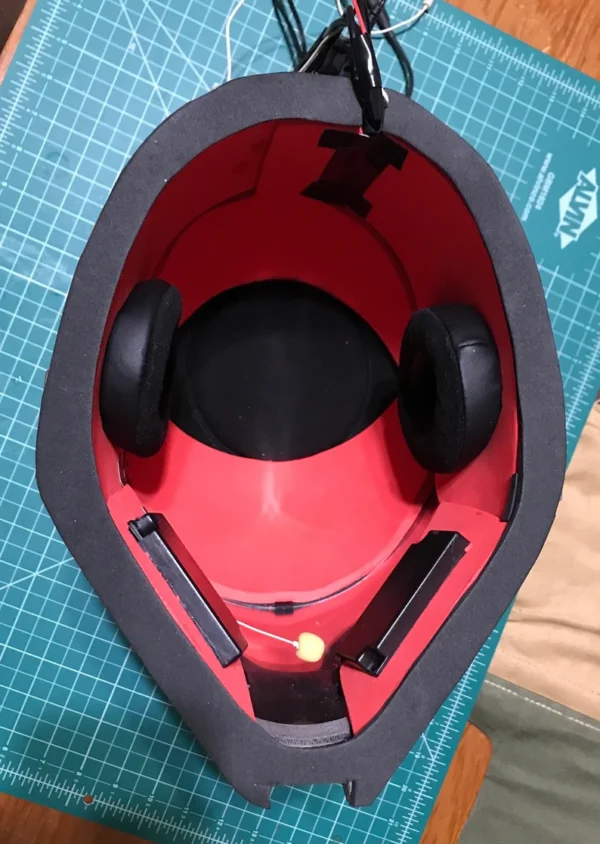 A red and black helmet sitting in the middle of a table.