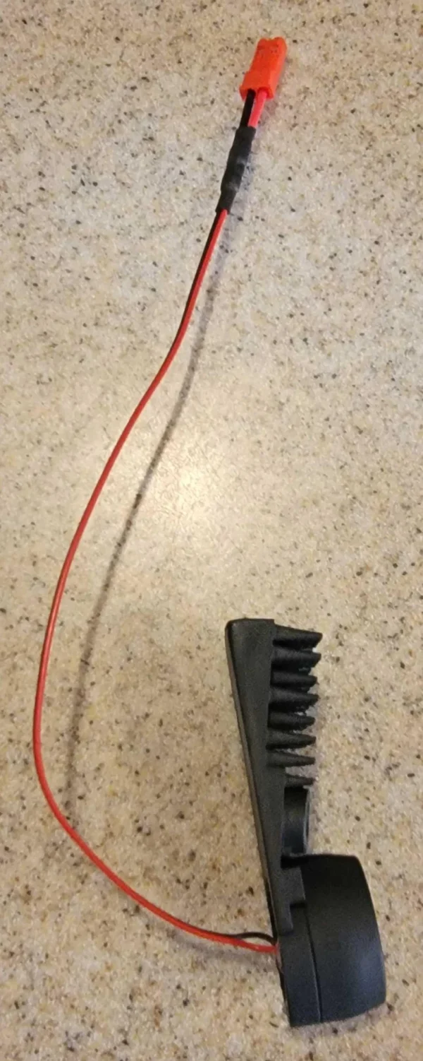 A red wire is next to a black comb.