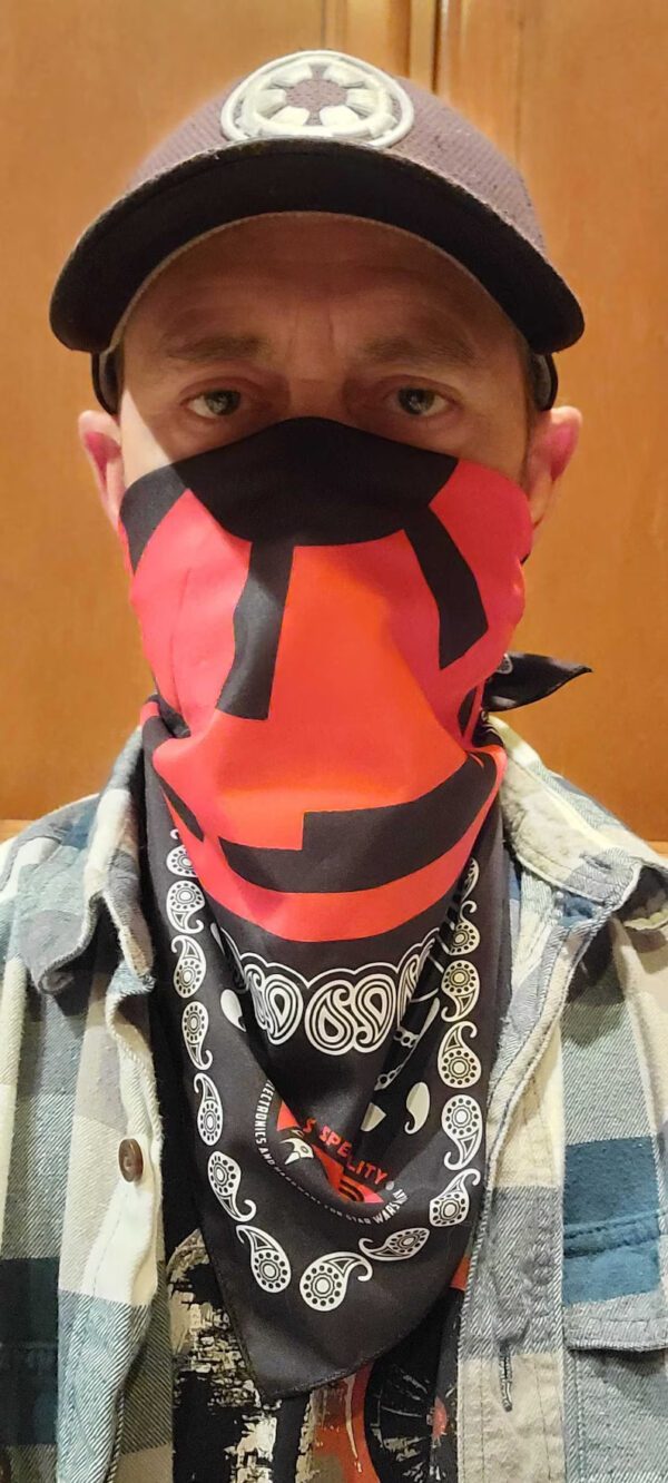 A man wearing a red and black face covering.